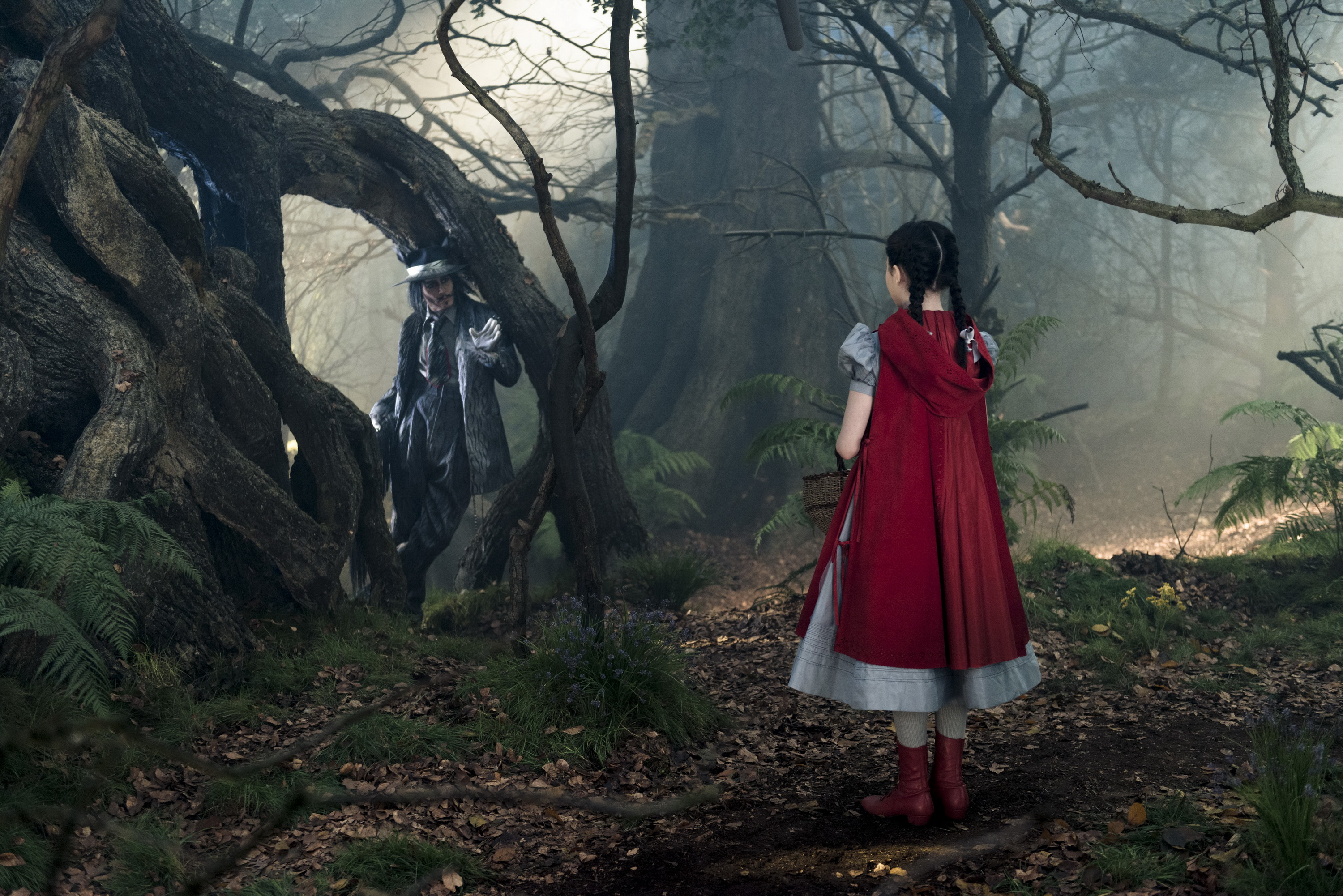 Johnny Depp as the Wolf and Lilla Crawford as Little Red Riding Hood in Disney's humorous and heartfelt musical INTO THE WOODS, directed by Rob Marshall and produced by John Deluca, Rob Marshall, Marc Platt and Callum McDougall.